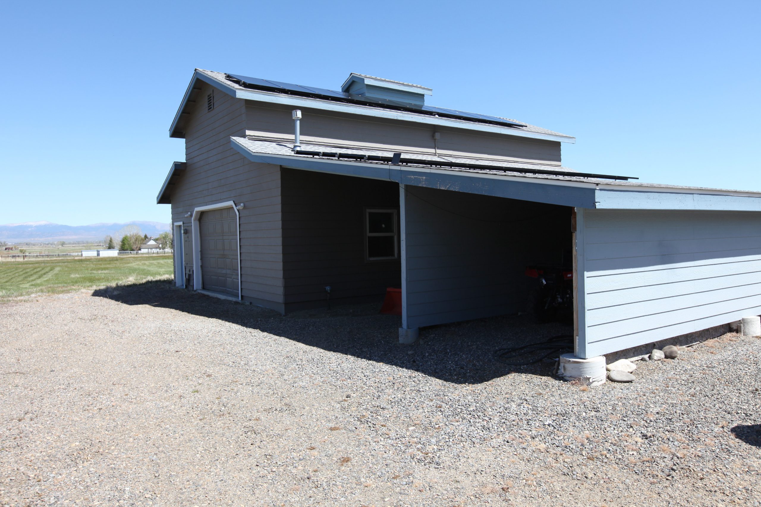 Garage viewed from back side and gravel parking area
