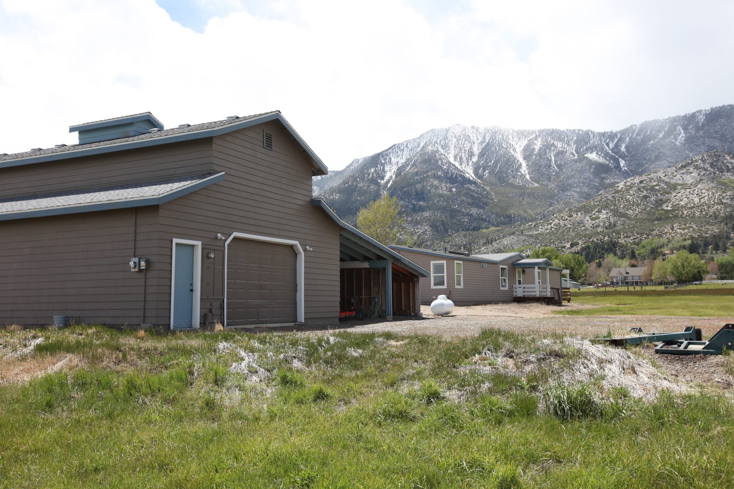 Back of barn with garage door, covered parking, and mountain view
