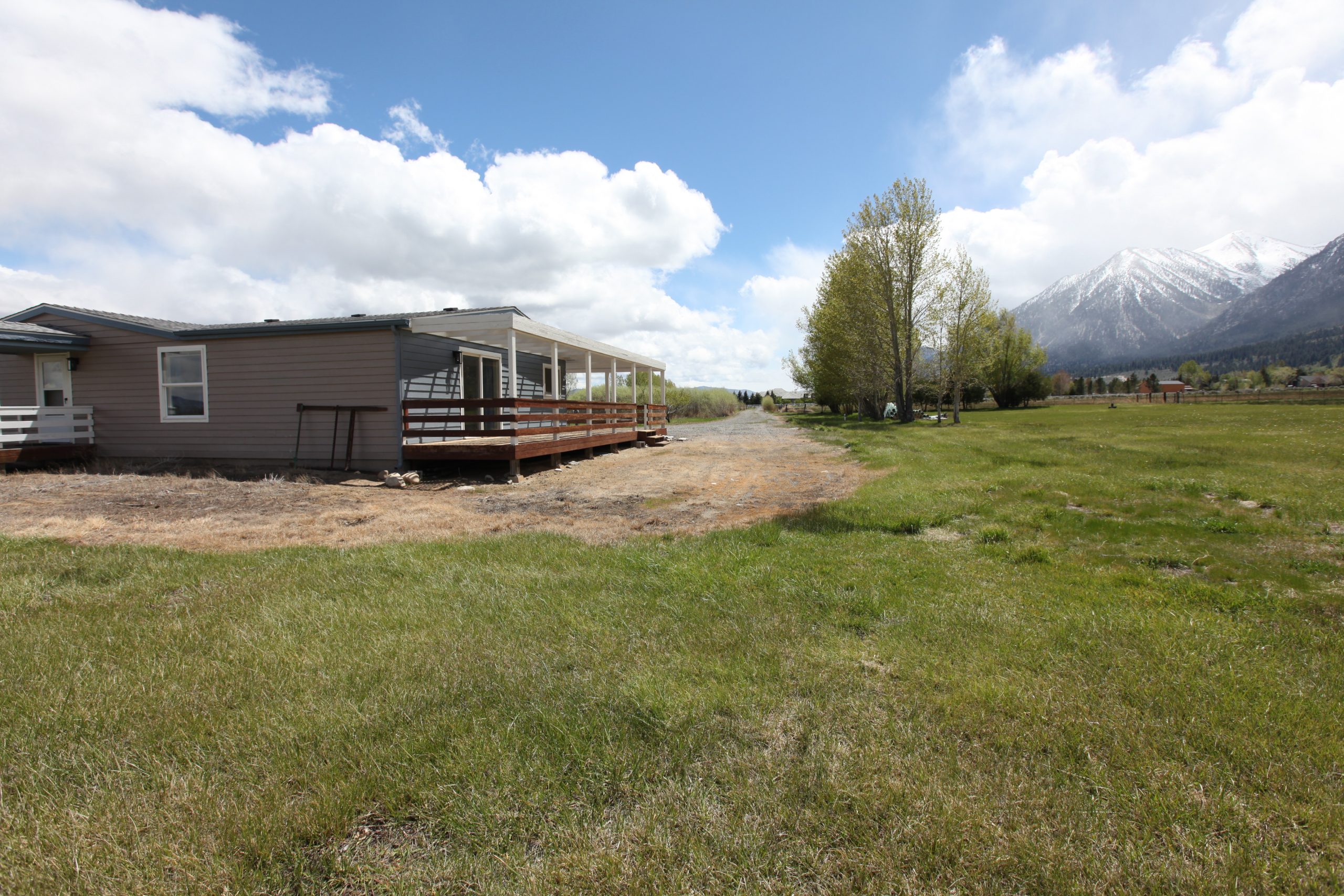 Rear of house with deck, pasture, and trees on west side